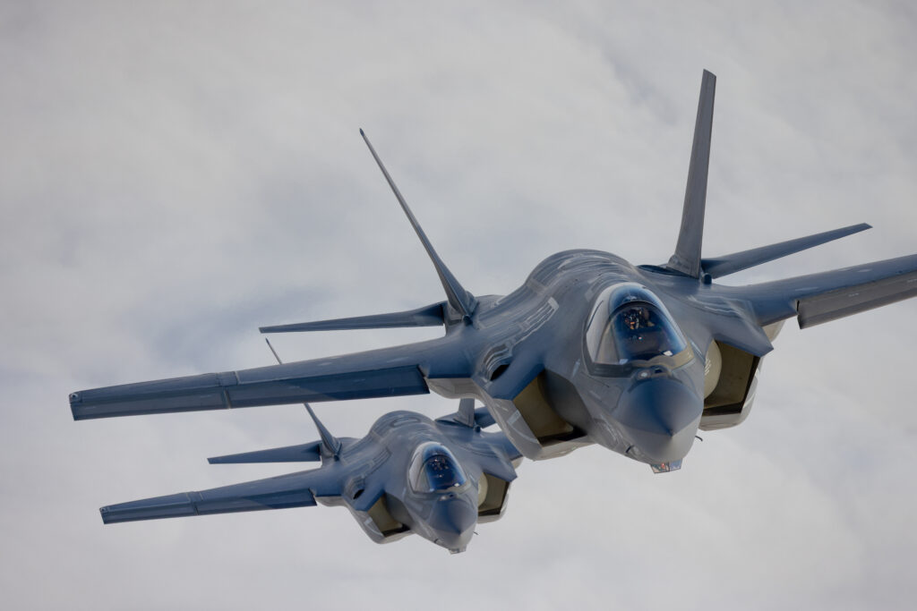 Very close top view of a pair of F-35C Lightning II over clouds